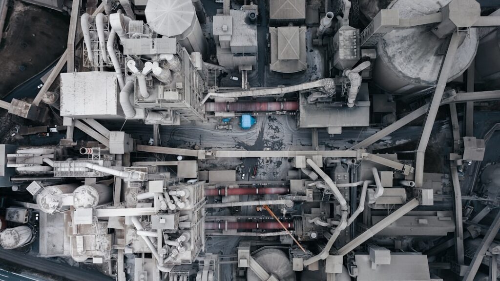 Futuristic autonomous robot arm assembling components in sleek industrial factory, holographic data overlay, cool blue ambient lighting, human engineer monitoring, professional tech setting