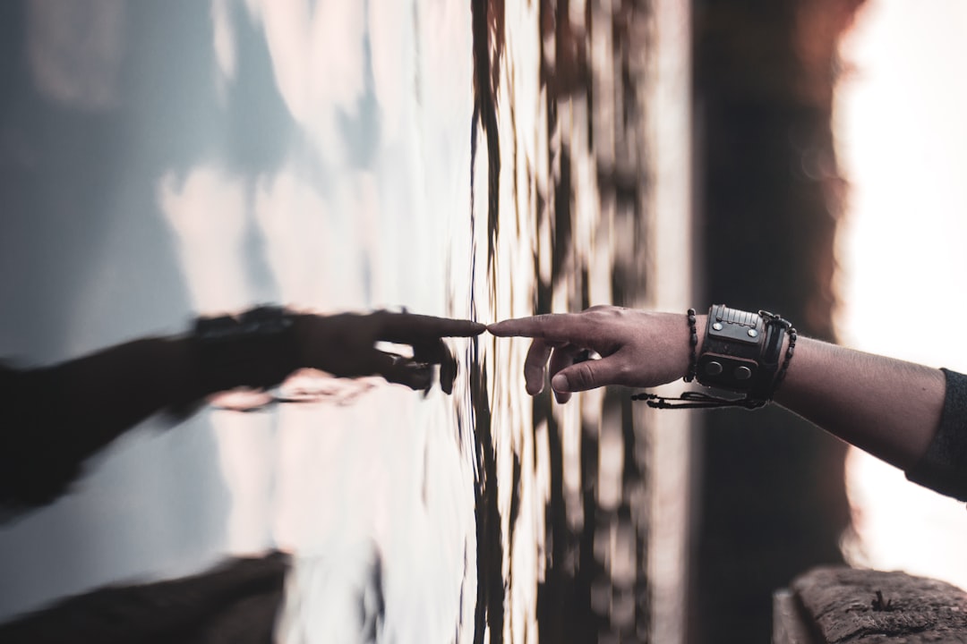 Split screen of robotic AI hand and human hand reaching toward each other with digital lock symbol, dramatic moody lighting, clean modern office background, AI ethics concept