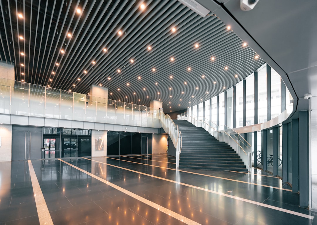 Wide angle interior of modern NVIDIA data center with rows of sleek black server racks illuminated by cool blue LED status lights, solid-state battery modules integrated seamlessly into infrastructure