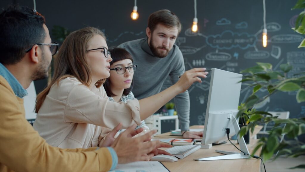 Diverse group of young professionals studying around holographic cloud computing display in sleek modern classroom, warm ambient lighting, futuristic tech education setting, inclusive digital learning