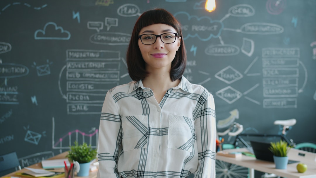 Young Filipino woman in sleek professional attire presenting holographic neural network visualization to diverse global audience in futuristic clean modern office with ambient cyan lighting