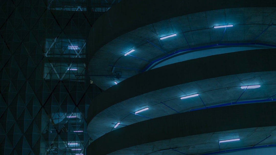 Futuristic government building with holographic AI interface overlay, sleek ambient blue lighting, professional bureaucrat interacting with transparent touchscreen, data streams, clean modern architec