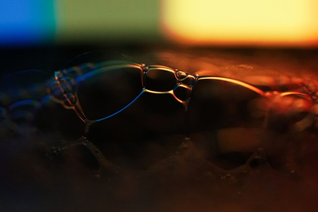 Futuristic transparent smart glasses on reflective surface with holographic data projections, executive silhouette in background, cool blue ambient lighting, corporate transparency concept