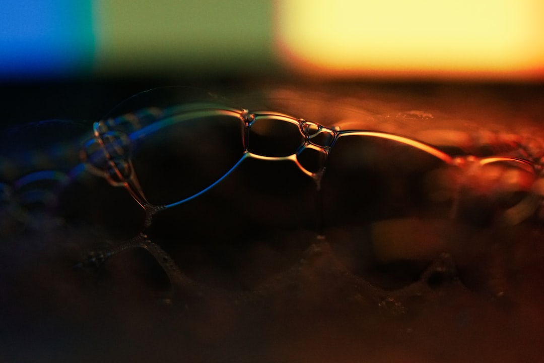 Futuristic transparent smart glasses on reflective surface with holographic data projections, executive silhouette in background, cool blue ambient lighting, corporate transparency concept