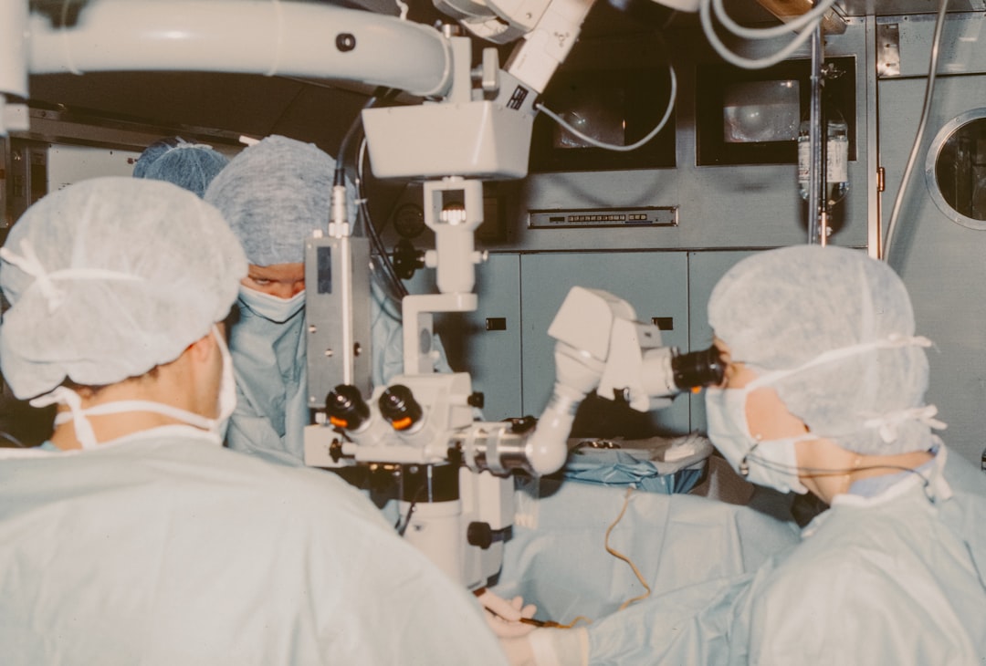 Surgeon's hands operating robotic surgical arm with holographic urology scan overlay, cool blue ambient lighting, sleek modern operating room, futuristic medical AI interface visible on transparent di