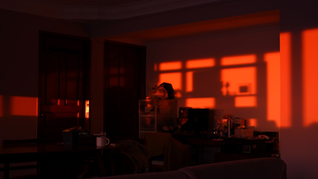 Solitary figure in minimalist apartment bathed in warm screen light from multiple devices, digital connection visualization floating around them, contrasted with empty physical space, moody cinematic 