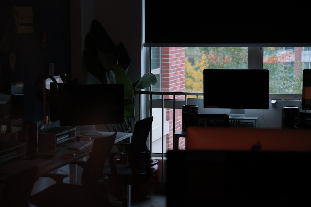 Clean modern office with multiple screens showing Python code, diverse professional developers collaborating, sleek ambient lighting, productivity dashboard hologram