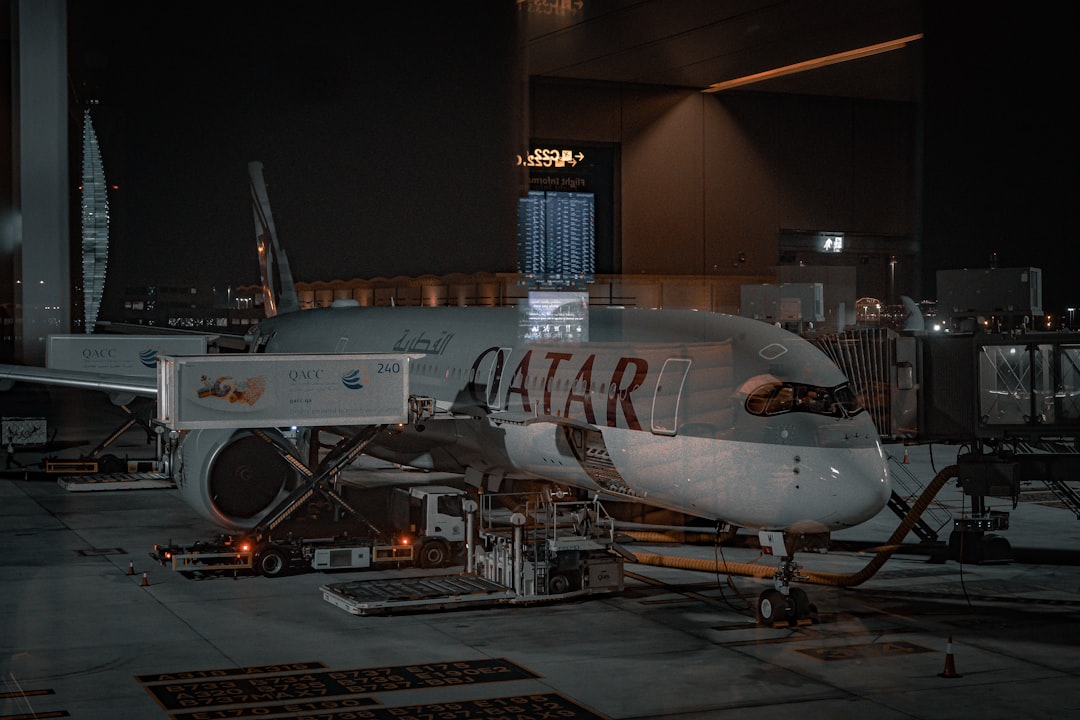 Futuristic Airbus aircraft hangar with holographic AI interface overlay, professional engineers collaborating, sleek ambient lighting, data visualization screens, sovereign technology concept, clean m