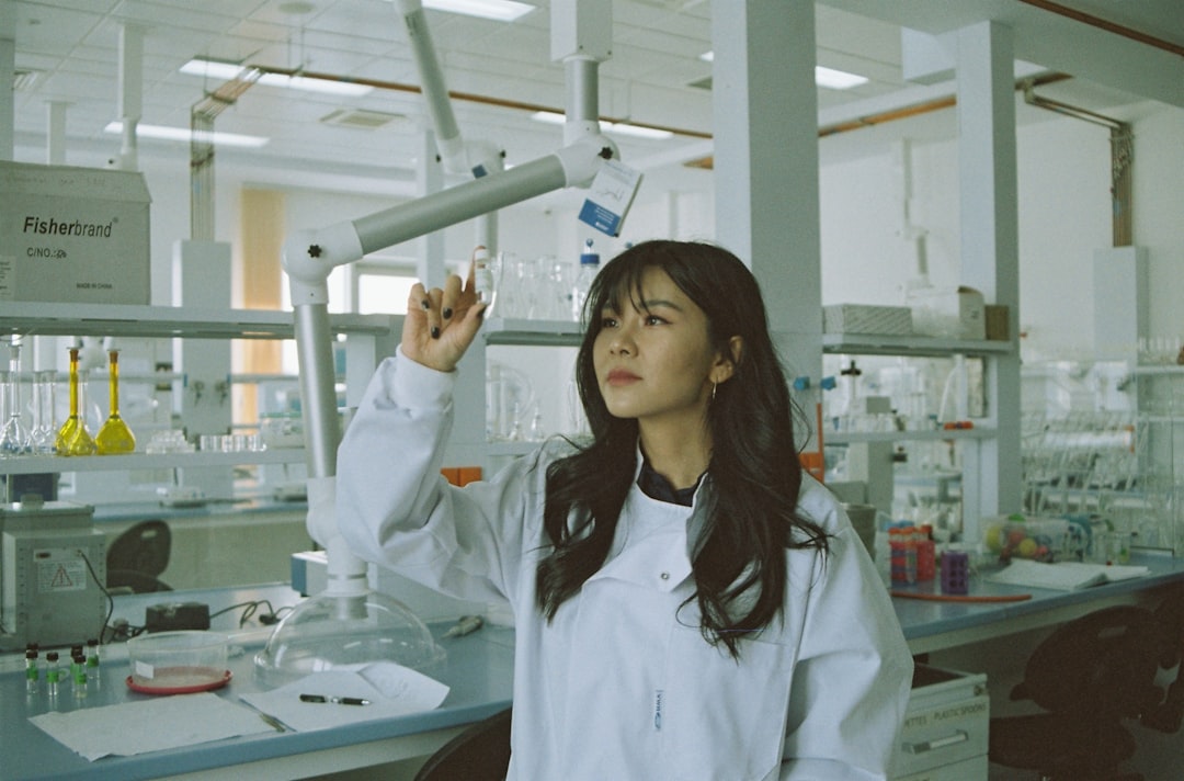 Young medical AI researcher and senior doctor examining transparent holographic patient data together in futuristic hospital corridor, soft ambient lighting, hopeful human-robot collaboration atmosphe