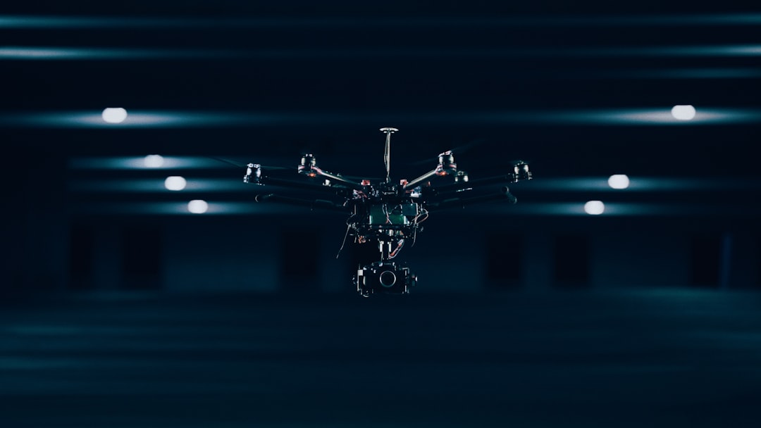 Futuristic smart factory floor with sleek robotic arms assembling components, holographic data overlays, ambient blue LED lighting, professional engineer monitoring production, clean modern industrial