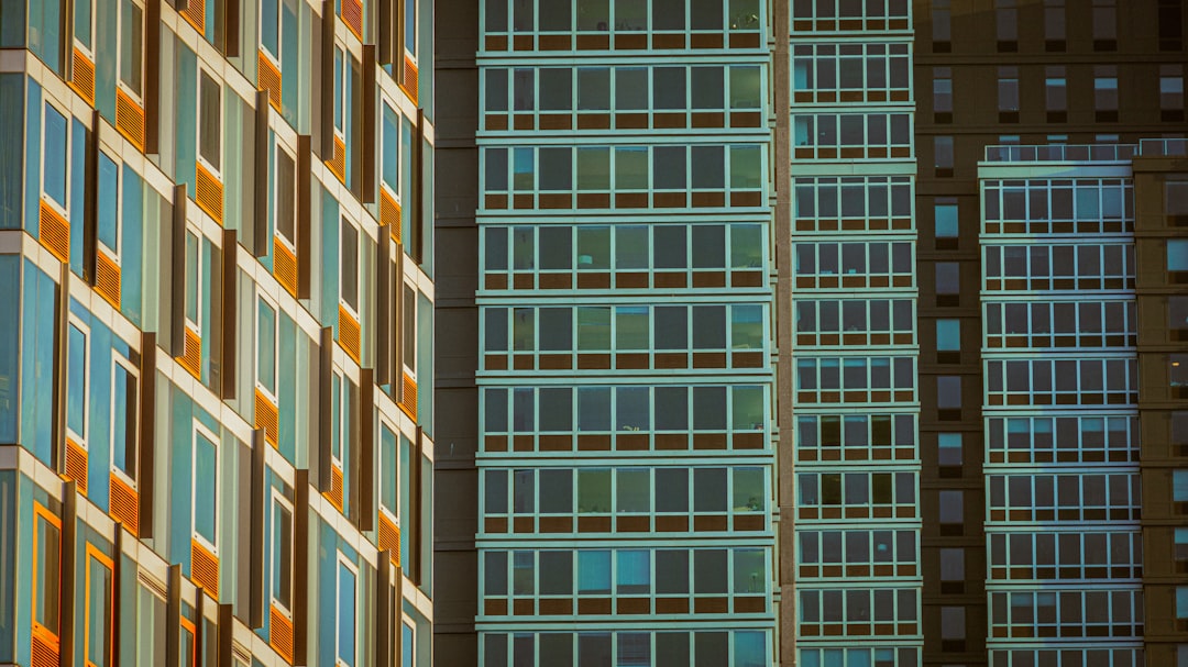 Split screen comparison of open source code on laptop versus corporate glass skyscraper, dramatic lighting, developer hands typing, modern clean office environment