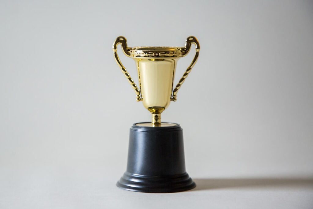 Prestigious golden trophy award on sleek glass pedestal with holographic neural network projection, futuristic dark museum lighting, professional editorial style, technology legacy concept