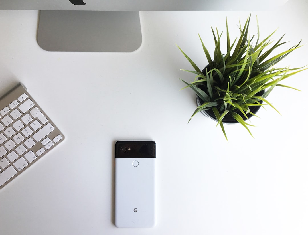 Close-up of sleek holographic Google ecosystem interface floating above clean modern office desk, professional using gesture control, ambient soft lighting, multiple integrated app icons, microchip de