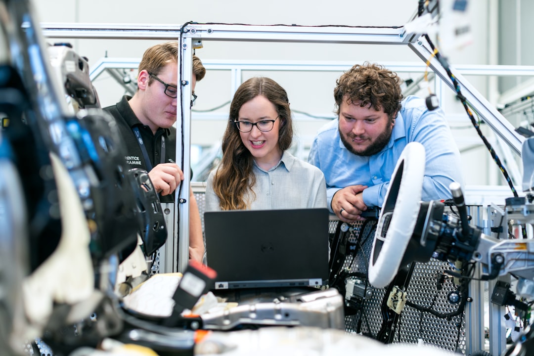 Diverse global tech engineers from Asia Europe Americas collaborating around holographic chip display, multiple competing neural networks visualized, breaking glass walls, clean modern data center