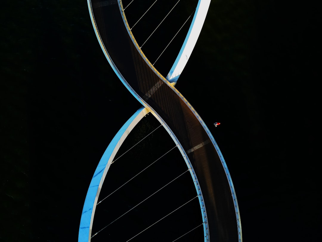 Futuristic DNA helix hologram floating above precision medical microchip, soft ambient teal and white lighting, sleek laboratory setting, personalized medicine technology, data visualization particles