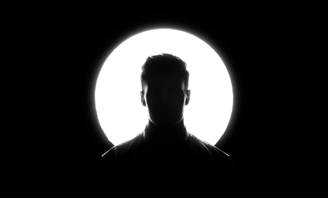 Futuristic silhouette of a person merging with holographic data streams in sleek server room, ambient blue lighting, neural network visualization overlay, professional tech atmosphere