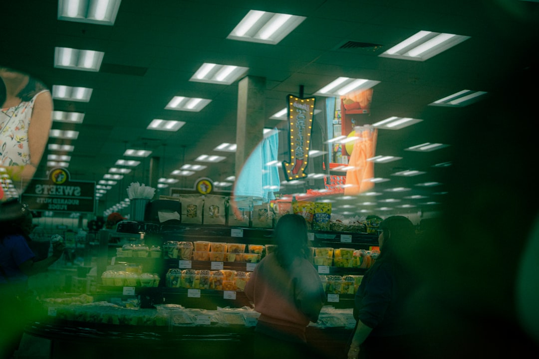 Futuristic supermarket checkout with customer using biometric payment, holographic personalized offers floating in air, warm ambient lighting, sleek modern retail design, AI facial recognition interfa