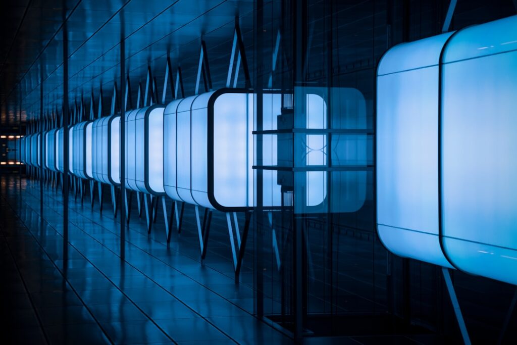 Futuristic data center interior with rows of glowing server racks, blue ambient lighting, holographic neural network visualization floating in foreground, professional tech environment