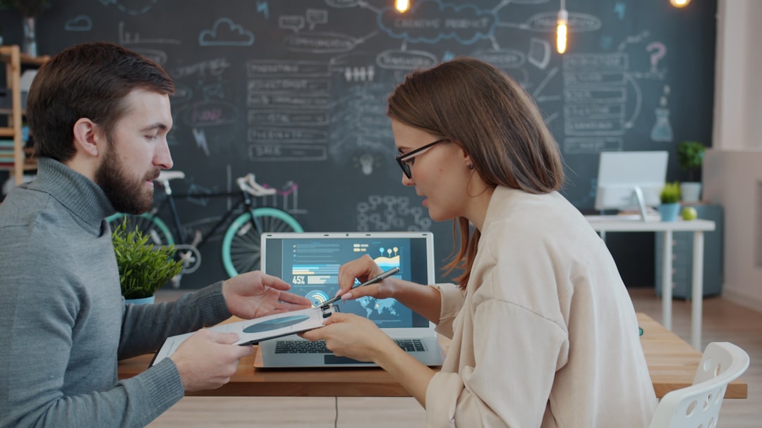 Close-up of AI-optimized marketing interface on tablet, small business owner reviewing campaign metrics, sleek touchscreen with colorful data streams, clean modern office background, soft ambient ligh