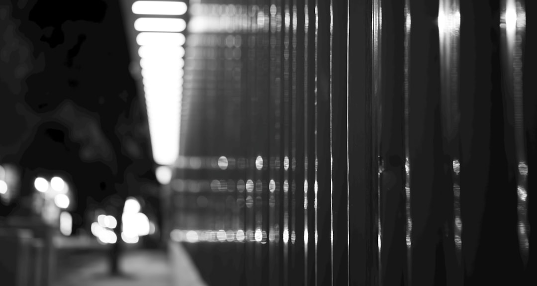Futuristic data center with dim ambient lighting, lone professional silhouette examining server racks, blue emergency lights, scattered holographic error alerts, mood of post-crisis technological reck