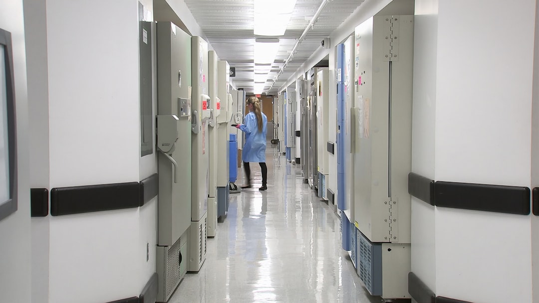 Modern Spanish hospital corridor with holographic medical AI diagnostic display floating above patient bed, professional healthcare team interacting with sleek interface, ambient warm clinical lightin
