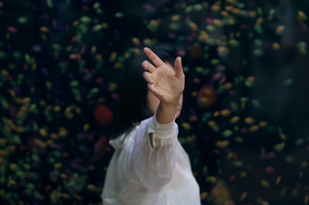 Close-up of diverse hands reaching toward transparent algorithmic decision tree display, AI ethics concept, dramatic side lighting, data center bokeh background, serious contemplative mood, documentar