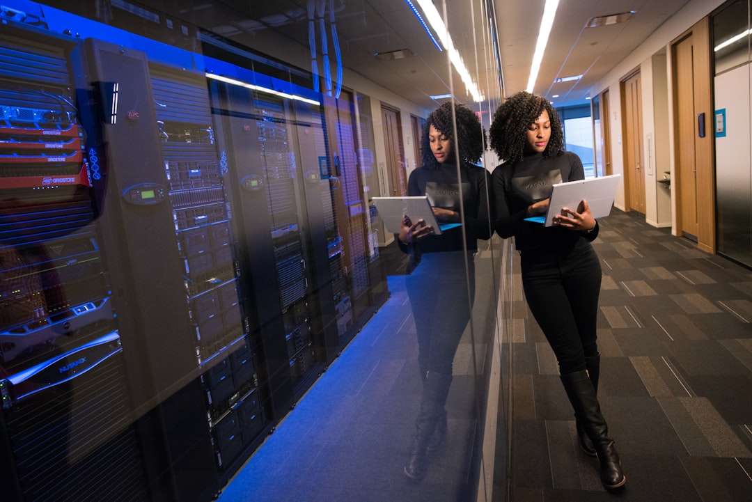 Wide shot of enterprise server room corridor, executive and engineer walking toward scalable AI infrastructure, clean lines, blue-green ambient lighting, governance holograms floating