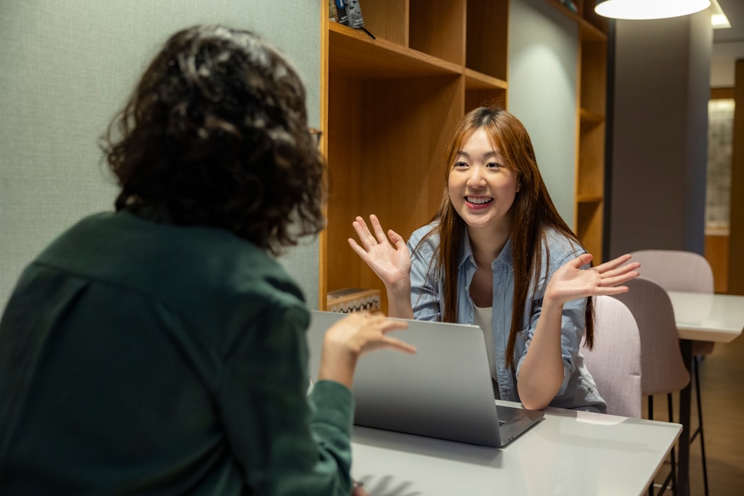 Professional teacher collaborating with friendly humanoid robot assistant in minimalist office, holographic lesson plans in air, warm ambient lighting, human-robot collaboration concept