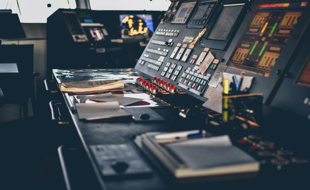 Futuristic industrial control room with holographic data displays, engineer analyzing multimodal sensor streams, sleek ambient blue lighting, neural network visualization overlaying factory floor