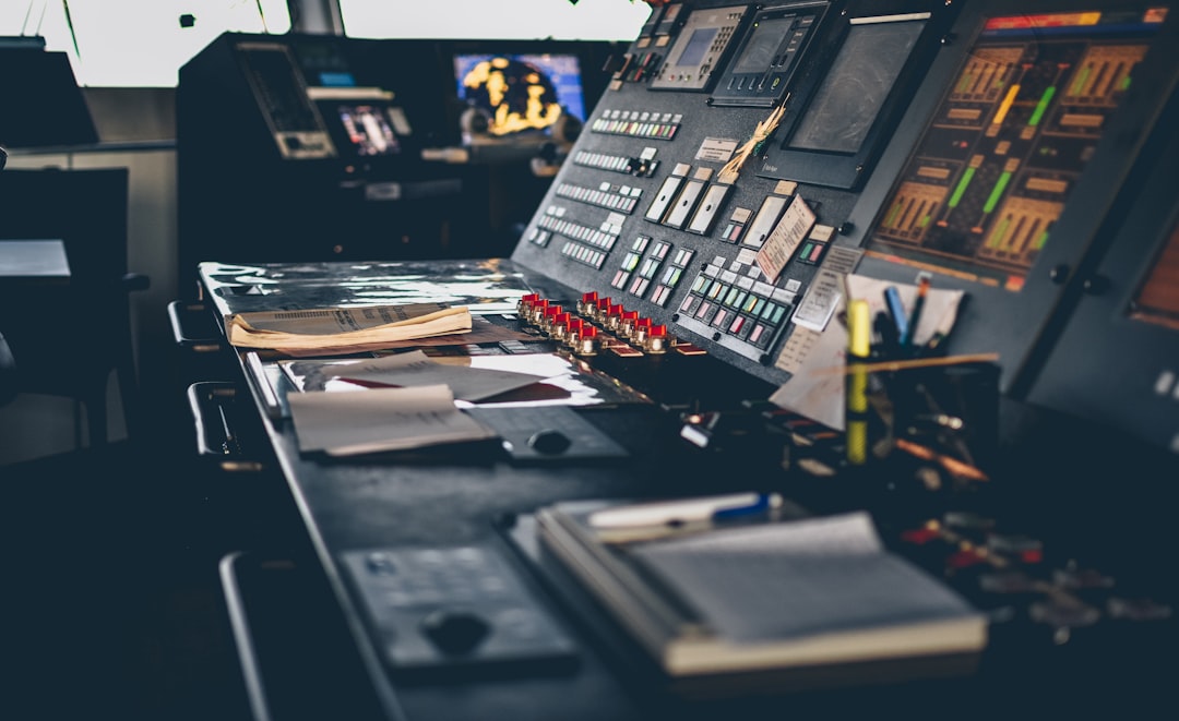 Futuristic industrial control room with holographic data displays, engineer analyzing multimodal sensor streams, sleek ambient blue lighting, neural network visualization overlaying factory floor