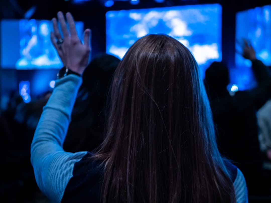 Diverse group of citizens viewing transparent digital voting system on large holographic display, blue ambient glow, modern government building, human rights technology concept