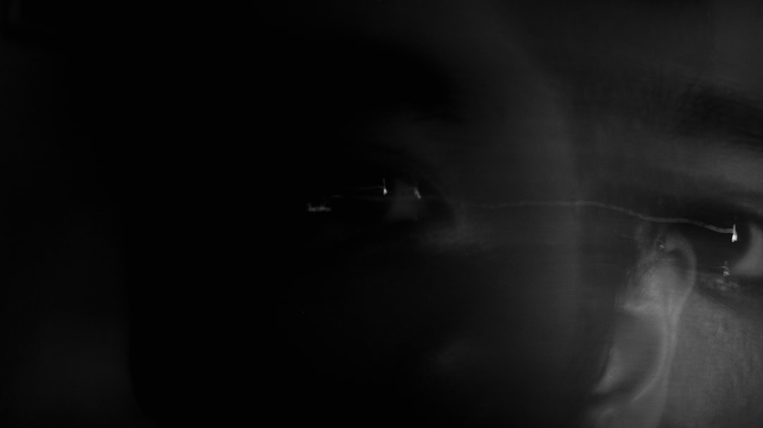 Close-up of human eye reflecting biased algorithmic code on screen, shadowy data patterns, moody dramatic lighting, AI neutrality concept, professional tech environment with tension