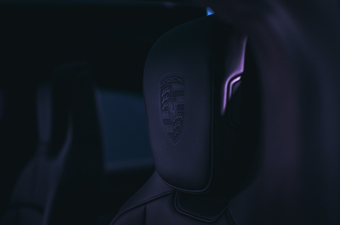 Personalized holographic interface floating above car seat, biometric data streams, ambient purple and teal lighting, premium materials, human silhouette interacting, sleek futuristic automotive cabin