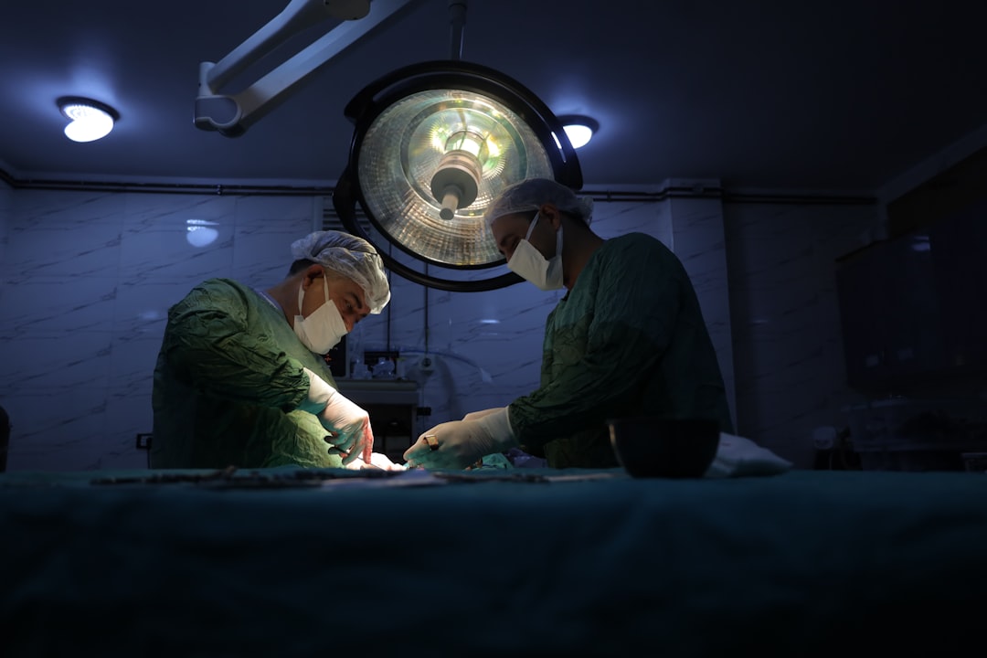 Close-up of robotic surgical arm with glowing microchip details, surgeon hands guiding precision instrument, sterile operating room with data overlay projections, cool clinical lighting