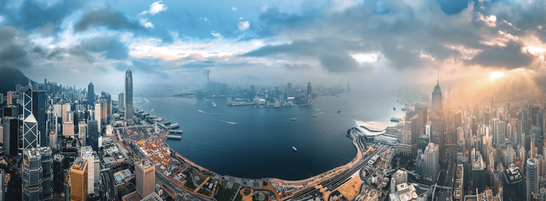 Human-robot collaboration in panoramic city skyline view, professional diverse team discussing holographic 2026 projections, warm golden hour lighting, clean modern office with microchip details