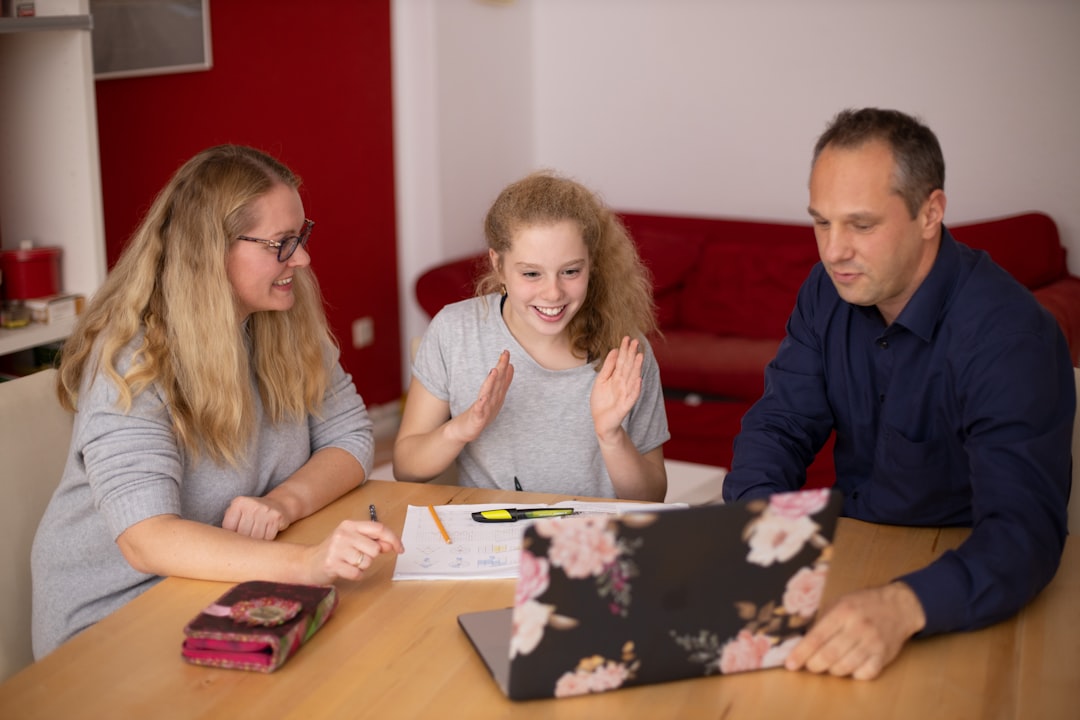 Worried parents studying AI ethics document on transparent tablet screen, dramatic side lighting, human silhouette against digital code background, cybersecurity dashboard reflections, professional ho
