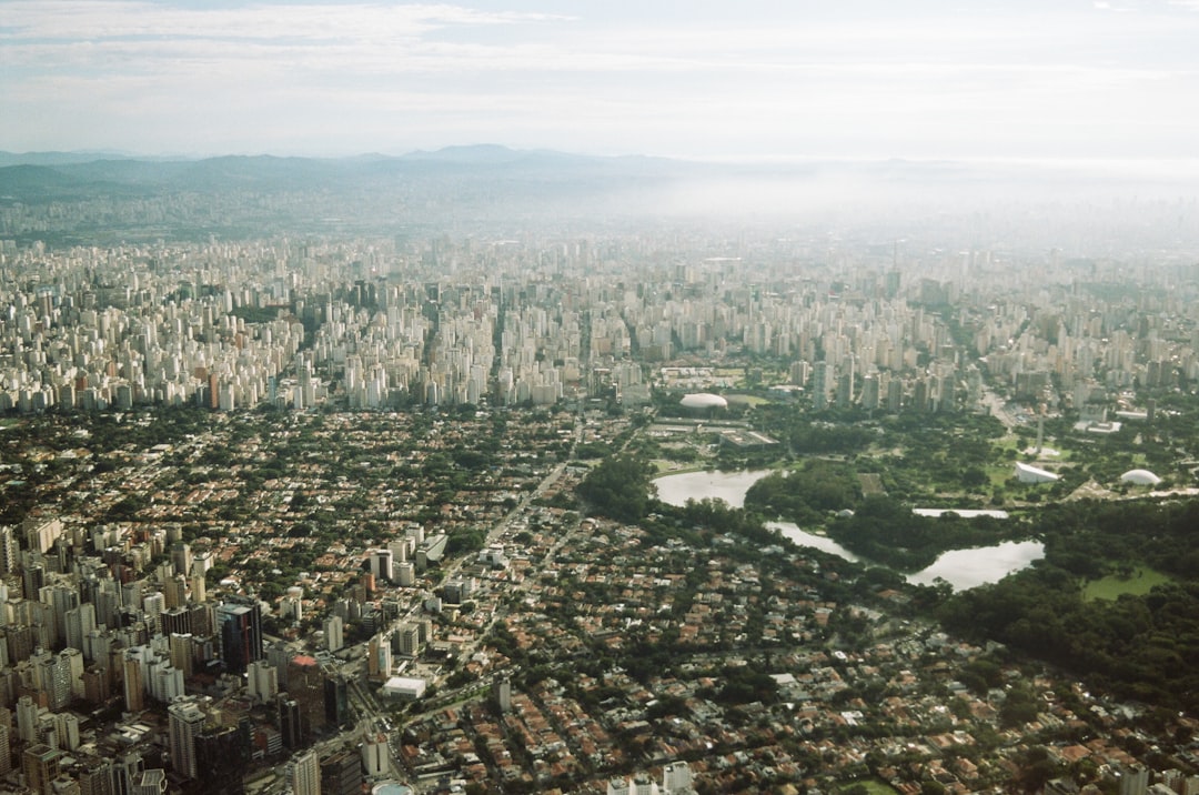 aerial view of modern Brazilian city with translucent holographic justice scale overlay, sleek data streams connecting government building to community, professional citizens interacting with digital 