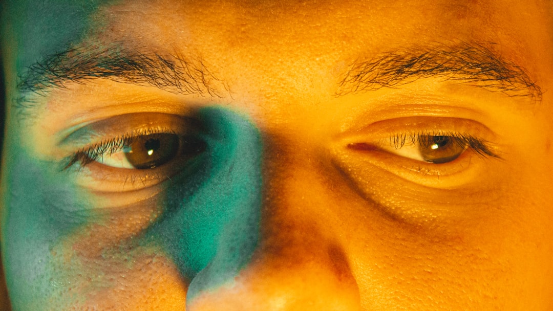 Split composition: cold blue neural network visualization on left, warm amber-lit human eyes showing empathy on right, shallow depth of field, bokeh particles, emotional contrast between machine preci