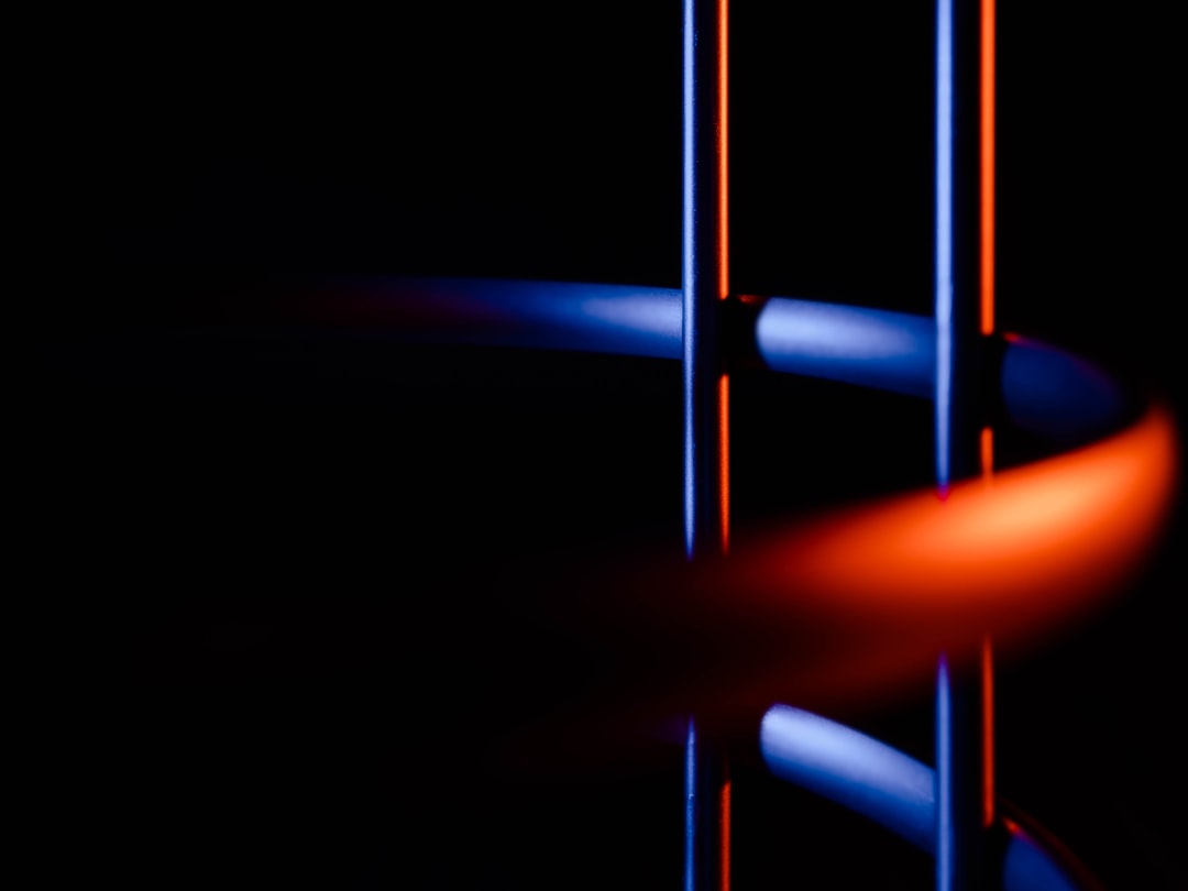 Dramatic macro photography of two advanced microchips facing each other on reflective black surface, electric blue and amber light trails clashing between them, circuit board patterns, futuristic batt