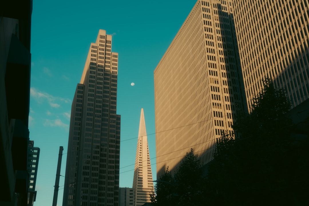 Professional aerial view of modern financial district at dusk with holographic stock charts and AI investment data overlays, sleek glass skyscrapers, ambient blue and gold lighting, clean modern offic