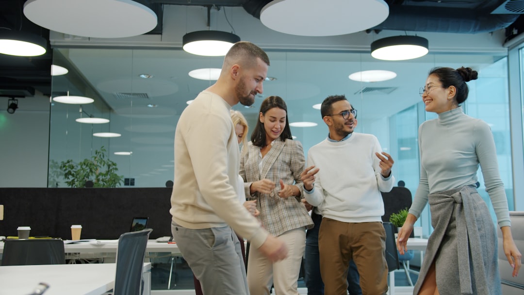 Sleek modern office with diverse professionals examining consumer behavior data streams, holographic marketing funnel floating above clean glass table, warm professional lighting
