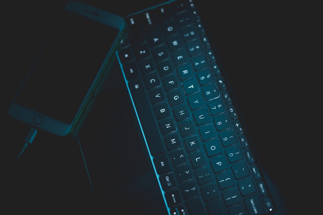 Close-up of hands typing on illuminated keyboard with holographic neural network visualization floating above, clean modern office, coding interface reflections on glass surface