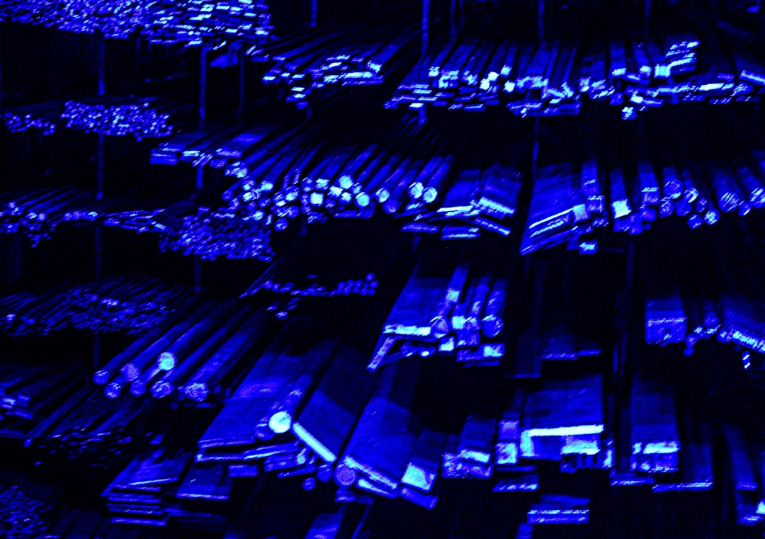 Futuristic data center with rows of glowing server racks, holographic neural network overlay, professional ambient blue lighting, technician in clean modern office monitoring AI infrastructure dashboa