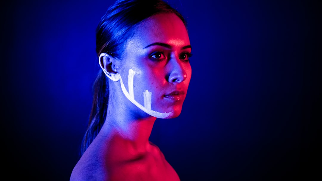 Sleek futuristic wearable earbuds floating with holographic neural network visualization, ambient blue lighting, clean modern tech aesthetic, professional product photography style