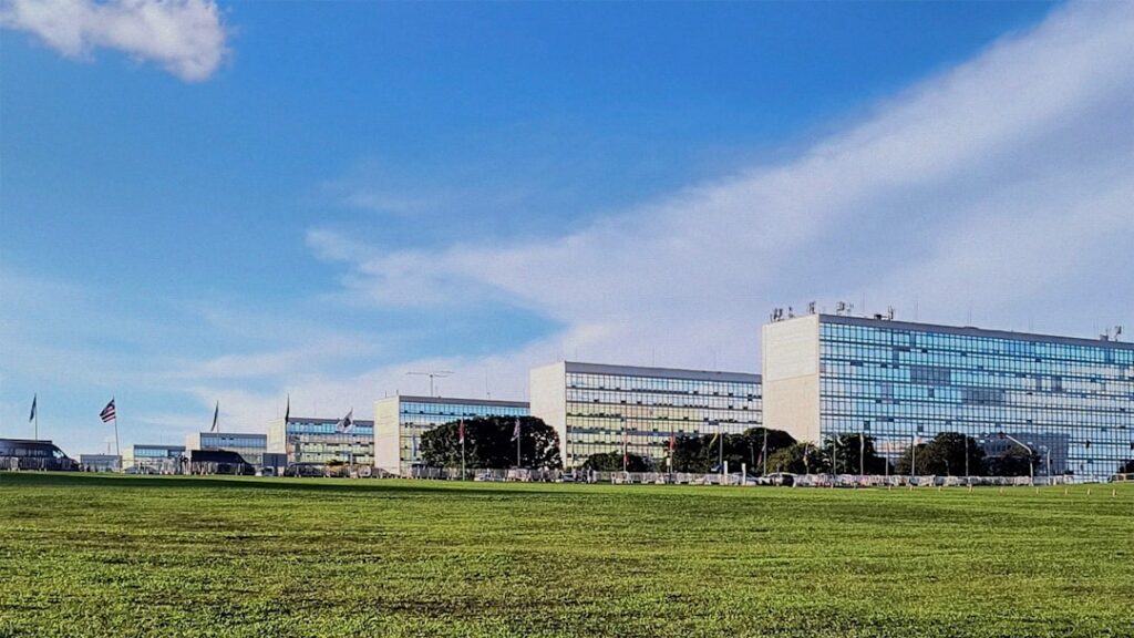 futuristic government office with holographic data dashboard displaying public procurement flows, professional analyst at sleek workstation, cool blue ambient lighting, neural network visualization ov