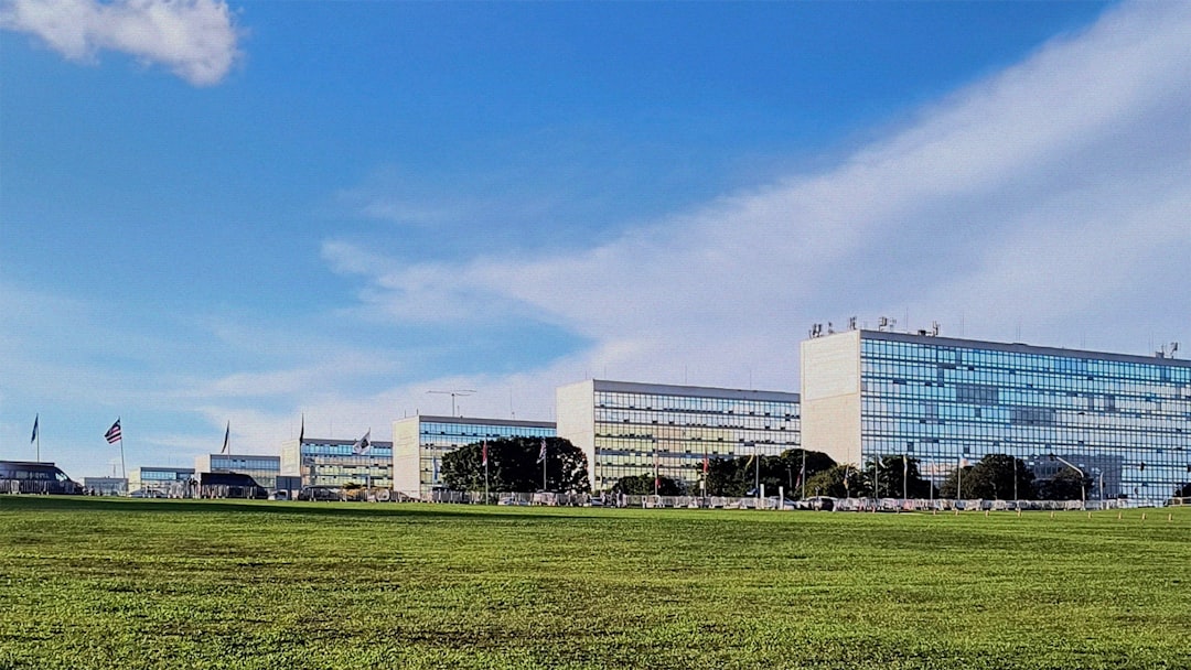 futuristic government office with holographic data dashboard displaying public procurement flows, professional analyst at sleek workstation, cool blue ambient lighting, neural network visualization ov