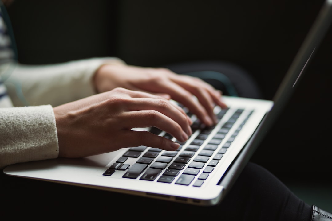 Close-up of hands typing on illuminated keyboard with holographic neural network visualization floating above, data center server room glow in background, cool blue and purple ambient lighting