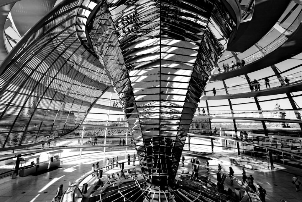 Sleek futuristic government building interior with holographic data displays and neural network visualizations, cool blue ambient lighting, professional tech policy setting, anonymous suited figures o