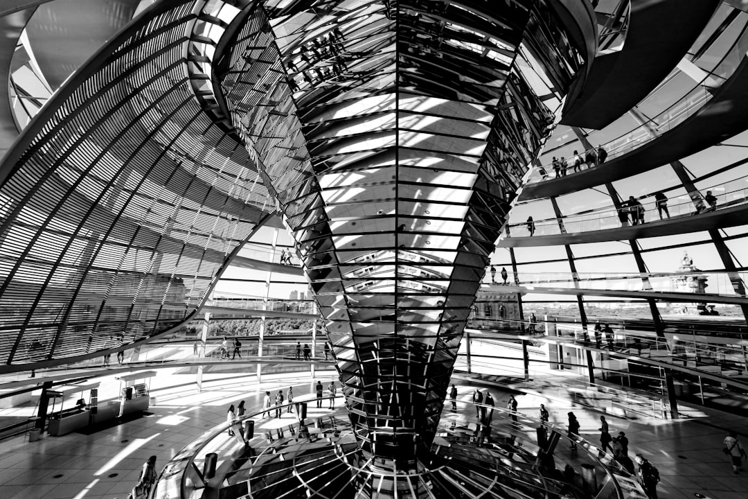Sleek futuristic government building interior with holographic data displays and neural network visualizations, cool blue ambient lighting, professional tech policy setting, anonymous suited figures o
