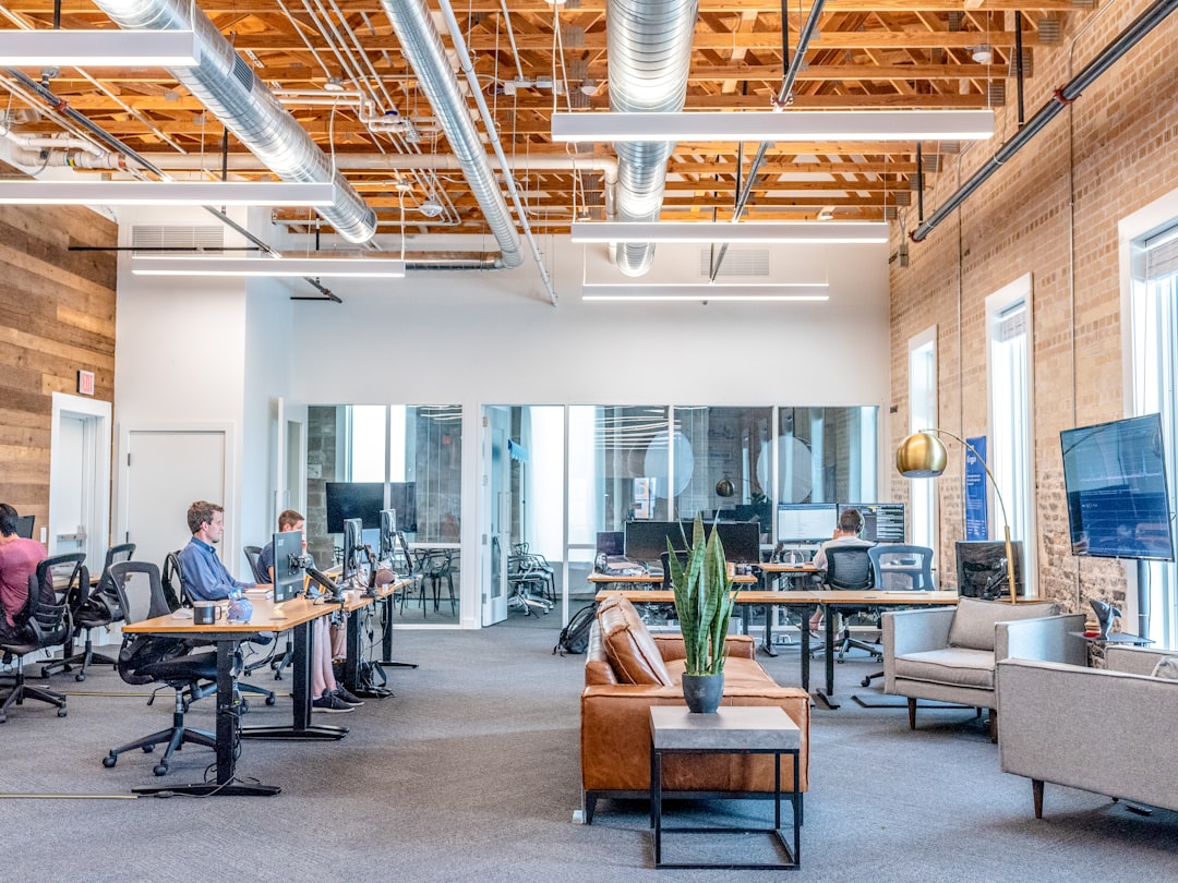 Clean modern office with professional team examining holographic AI analytics, sleek glass walls, ambient warm lighting, medical and logistics icons floating, human-AI collaboration in sovereign cloud